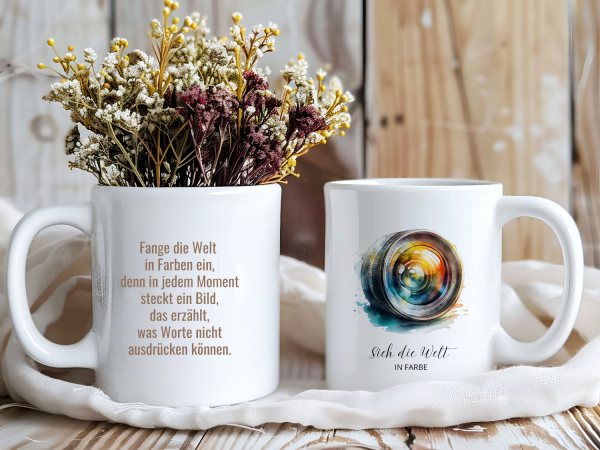 Zwei Fototassen mit Kameraobjektiv-Motiv und inspirierenden Sprüchen zur Fotografie: „Sich die Welt in Farbe“ und „Fange die Welt in Farben ein…“. Ideal als Geschenk für Fotografen, Kreative und Liebhaber der visuellen Kunst.
